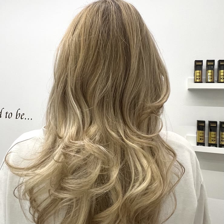 Svetel blond balayage z mehkimi valovi, pogled od zadaj